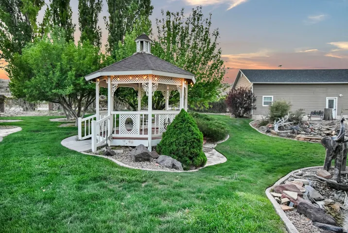 White wooden gazebo with a dark shingled roof and integrated lighting