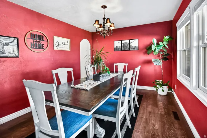 Dining area featuring rich red walls and wood-finish flooring
