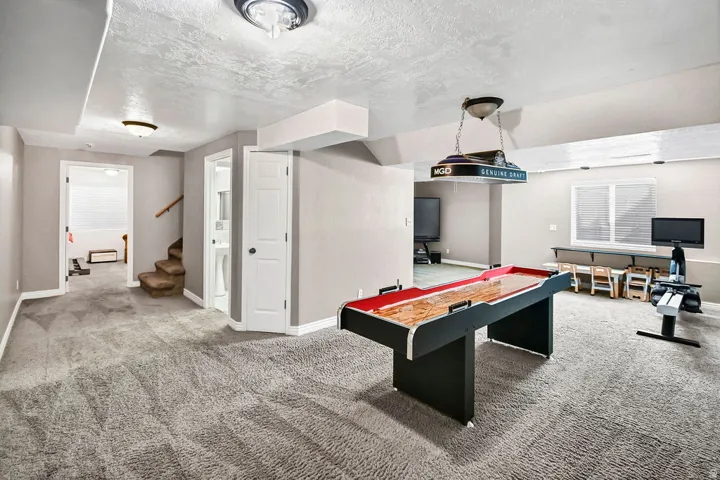 Spacious lower level featuring plush gray carpeting, light gray wall paint, and white trim