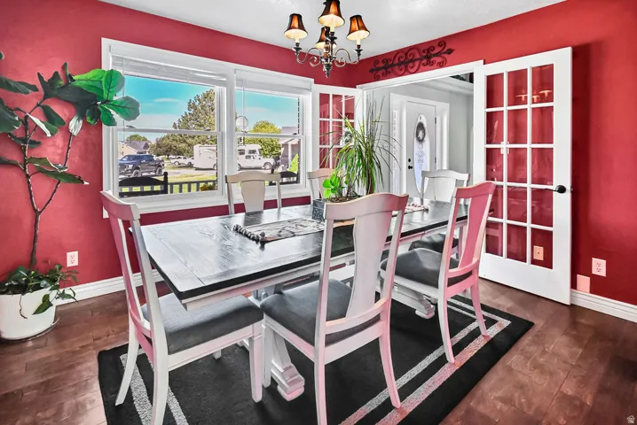 Dining space featuring rich wood-finish flooring and a decorative chandelier