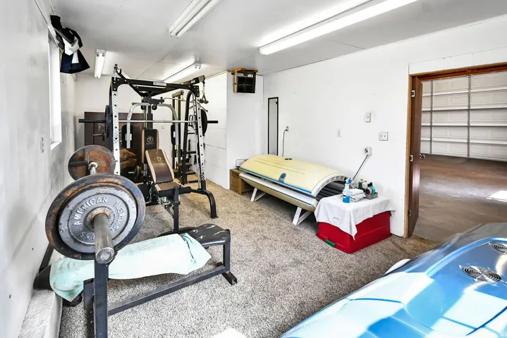 Carpeted multipurpose room with white walls and overhead fluorescent lighting