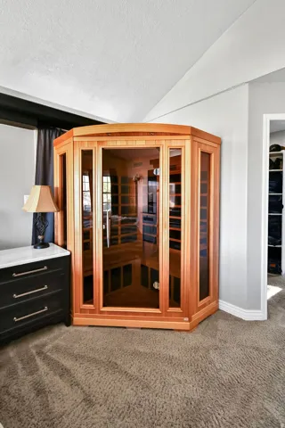 Corner sauna unit with wood-finish framing and glass panels