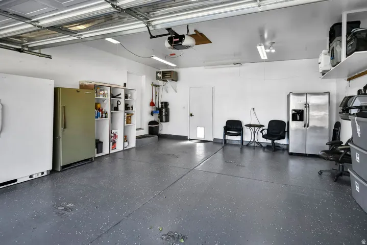 Spacious garage featuring a durable speckled epoxy floor, white walls, and bright overhead lighting
