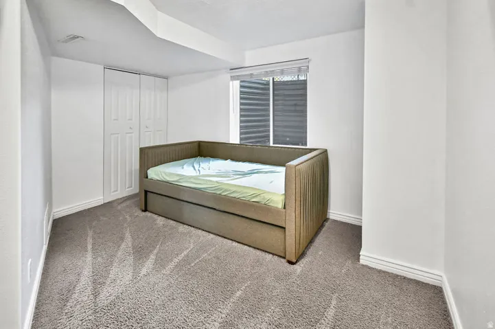 Spacious room featuring light gray carpeting, crisp white walls, and a recessed window