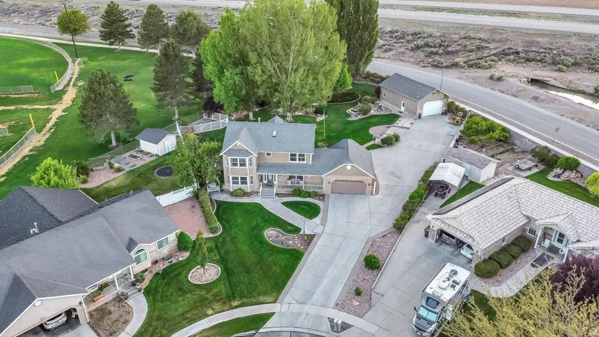 Two-story residence featuring a tan exterior, an attached two-car garage, and a large concrete driveway