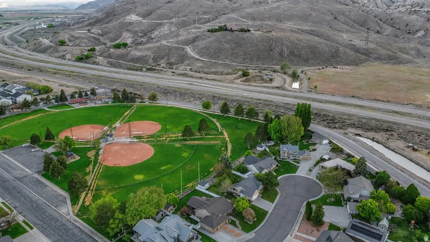 Aerial perspective showcasing a residential area with a prominent green park featuring three baseball diamonds