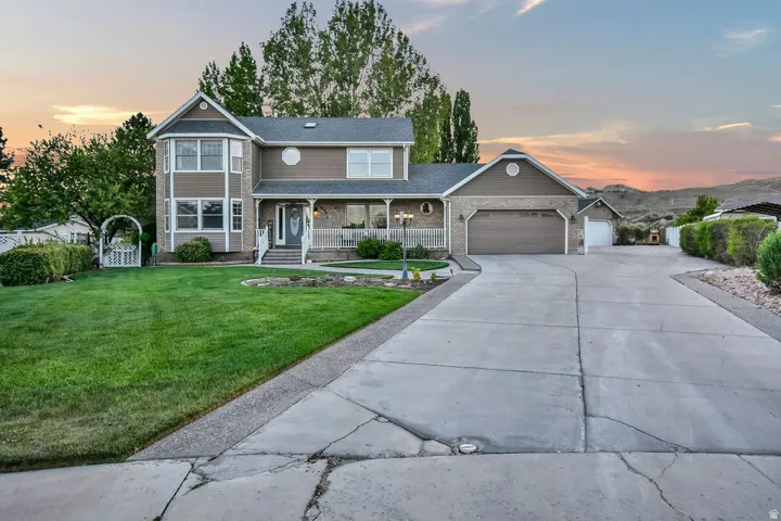 Two-story residence featuring a bay window, stone and siding exterior, and a covered front porch with white railing