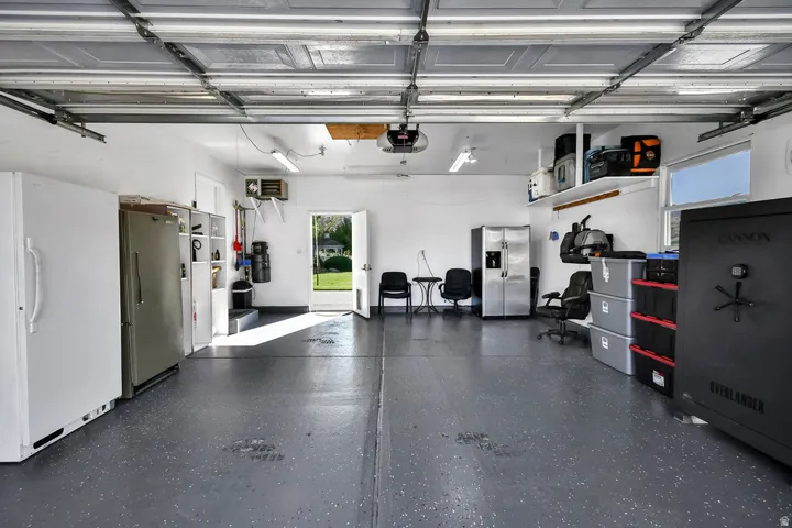 Spacious garage featuring a durable speckled epoxy floor, white painted walls, and overhead lighting