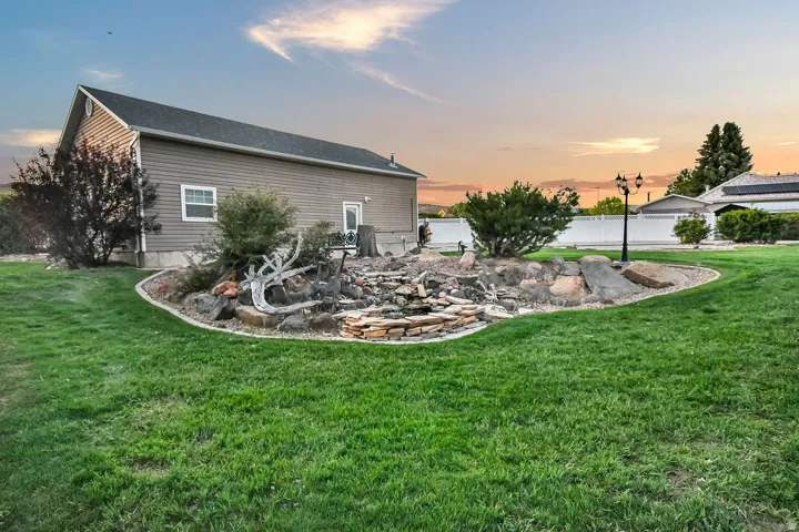 Expansive lawn with a decorative rock feature and stacked stone landscaping