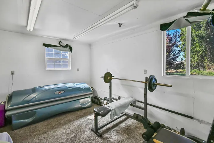 Interior room with white painted walls, two windows, and fluorescent overhead lighting