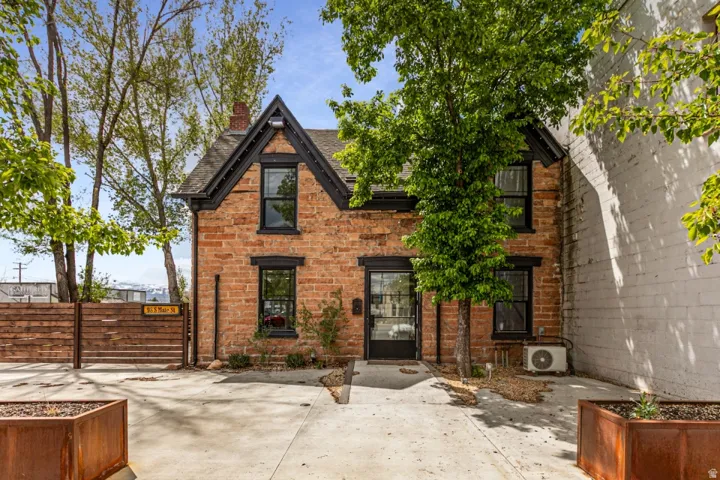 Brick exterior with dark trim windows and a black-framed glass entry door