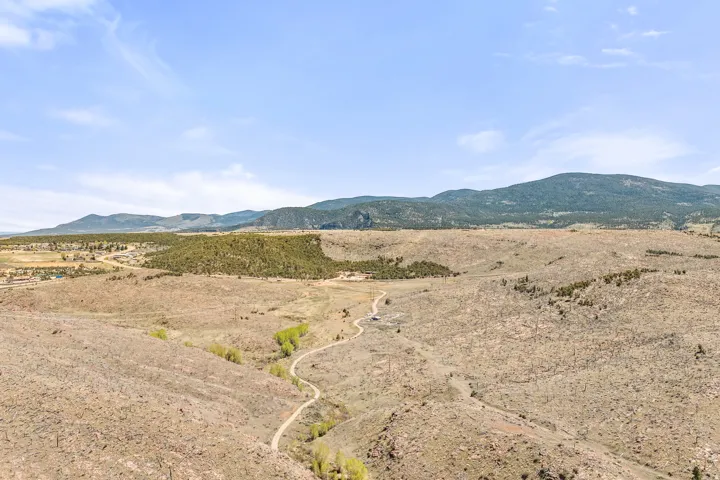 Expansive landscape featuring rolling hills and distant mountains