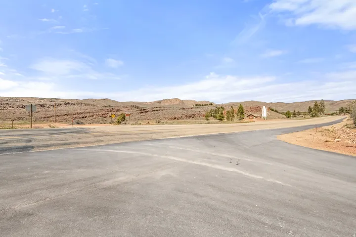 Paved roads provide access to the property, featuring a building with a white silo and surrounding natural landscape with distant rock formations