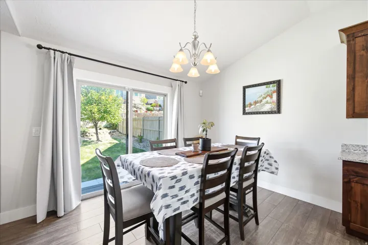 Dining area featuring a vaulted ceiling and wood-finish flooring