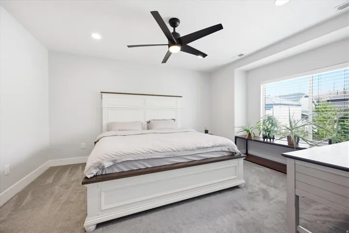 Bright room featuring a large window, recessed lighting, and a ceiling fan