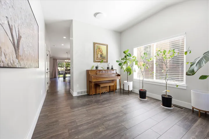 Spacious entryway featuring wood-finish flooring and a wide window with blinds