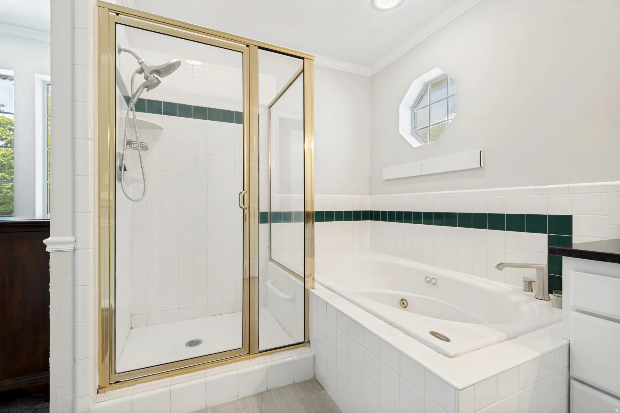 Shower with gold-toned framed glass enclosure, recessed lighting, and an octagonal window