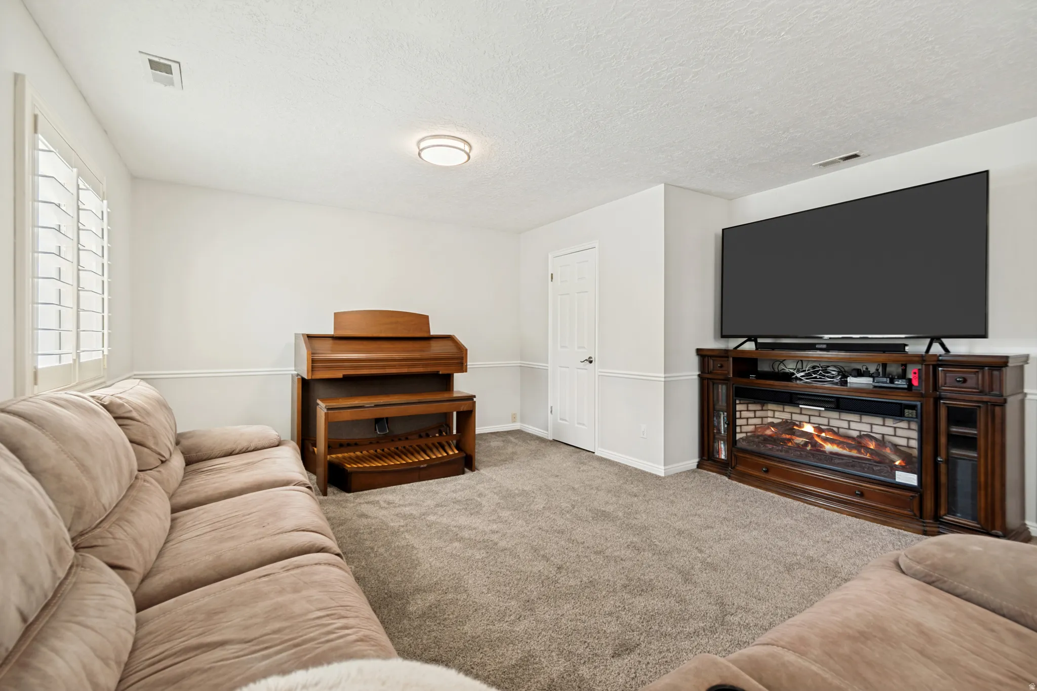Carpeted living area featuring white walls with chair rail molding