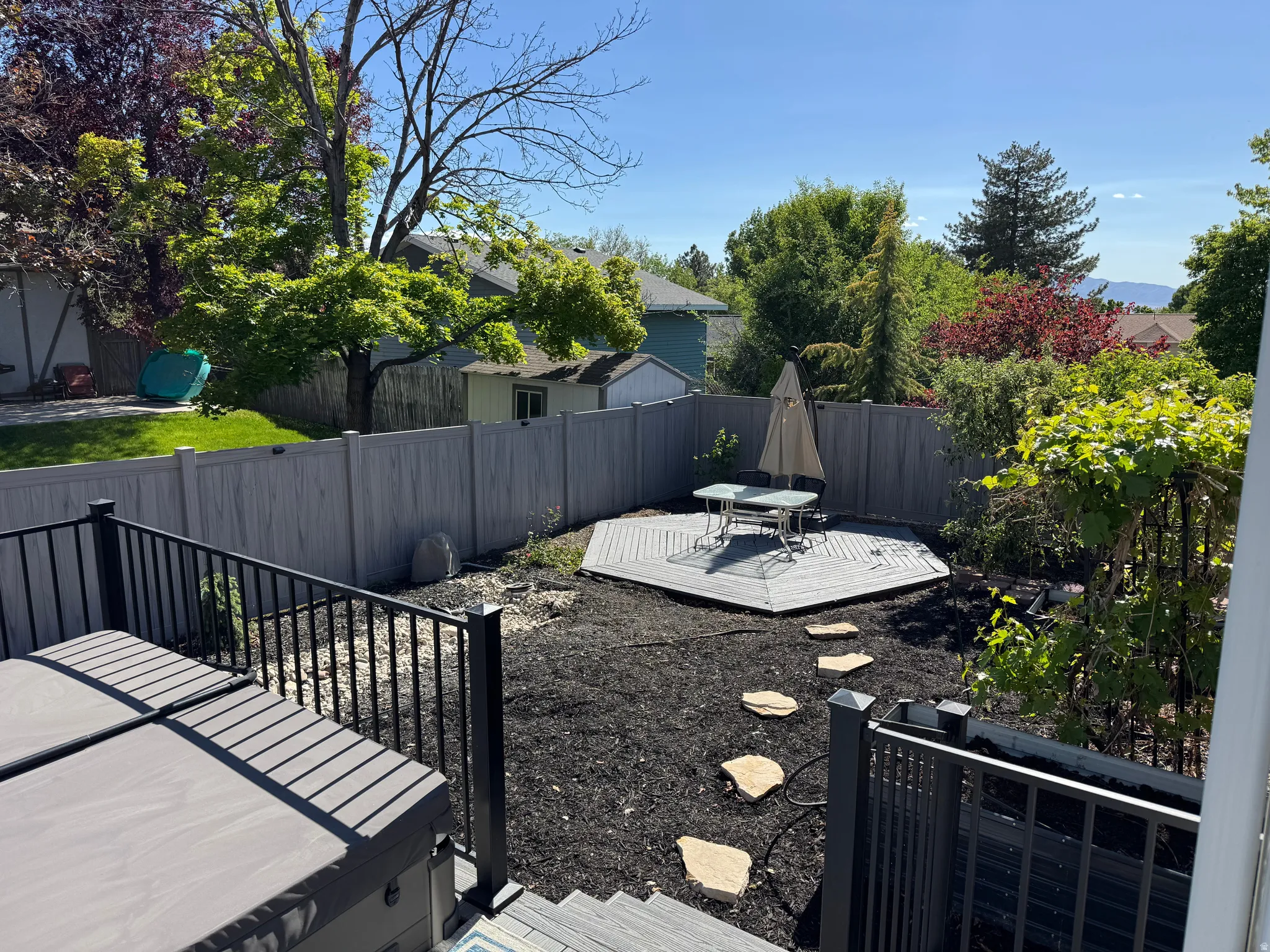 Backyard featuring a multi-level deck, composite fencing, and a dedicated octagonal patio