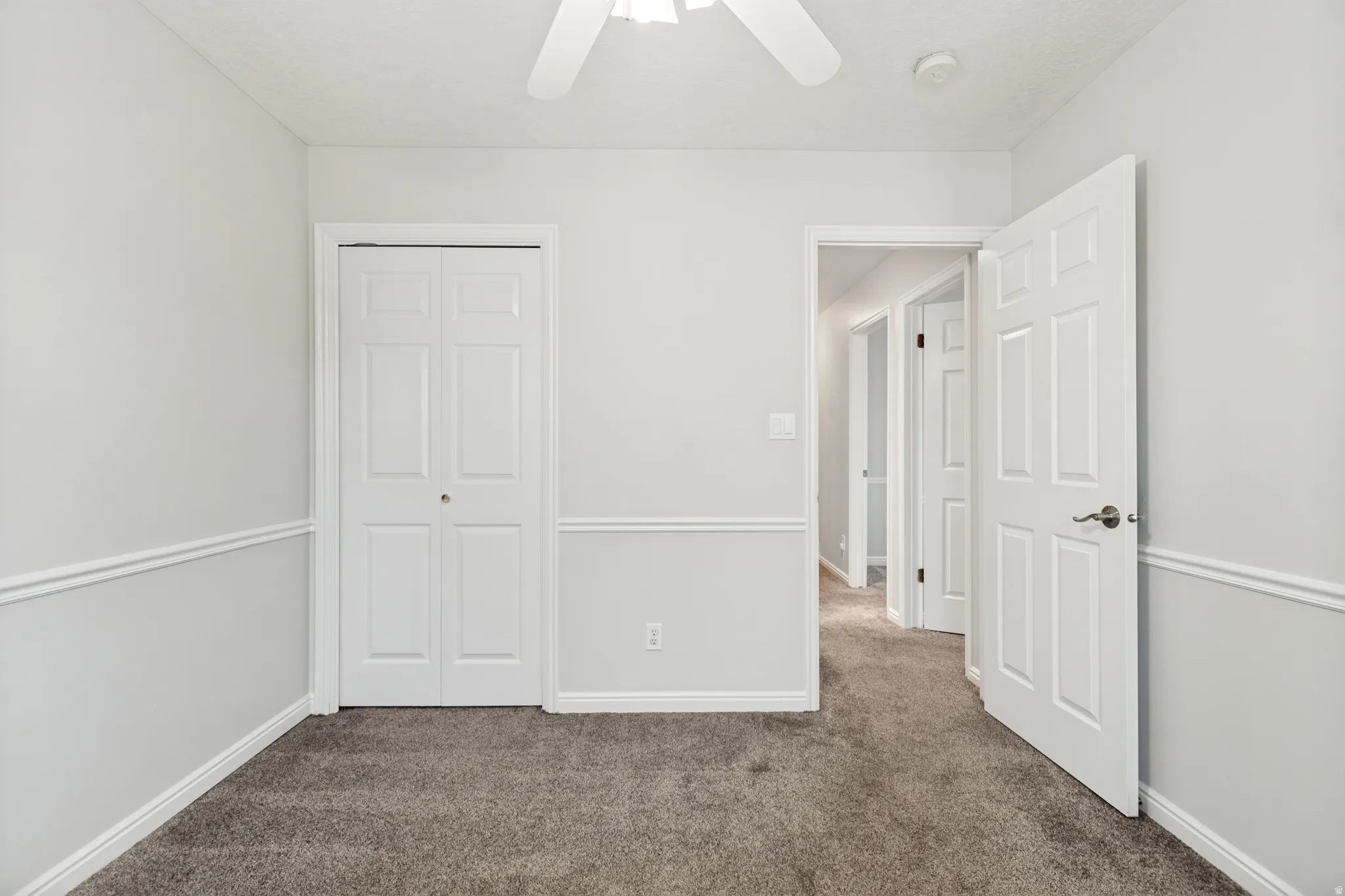 Neutral wall colors, white trim, and plush carpeting create a versatile interior