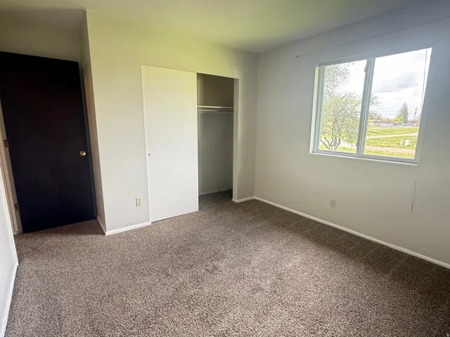 Carpeted room featuring a double-pane window, neutral wall paint, and white trim