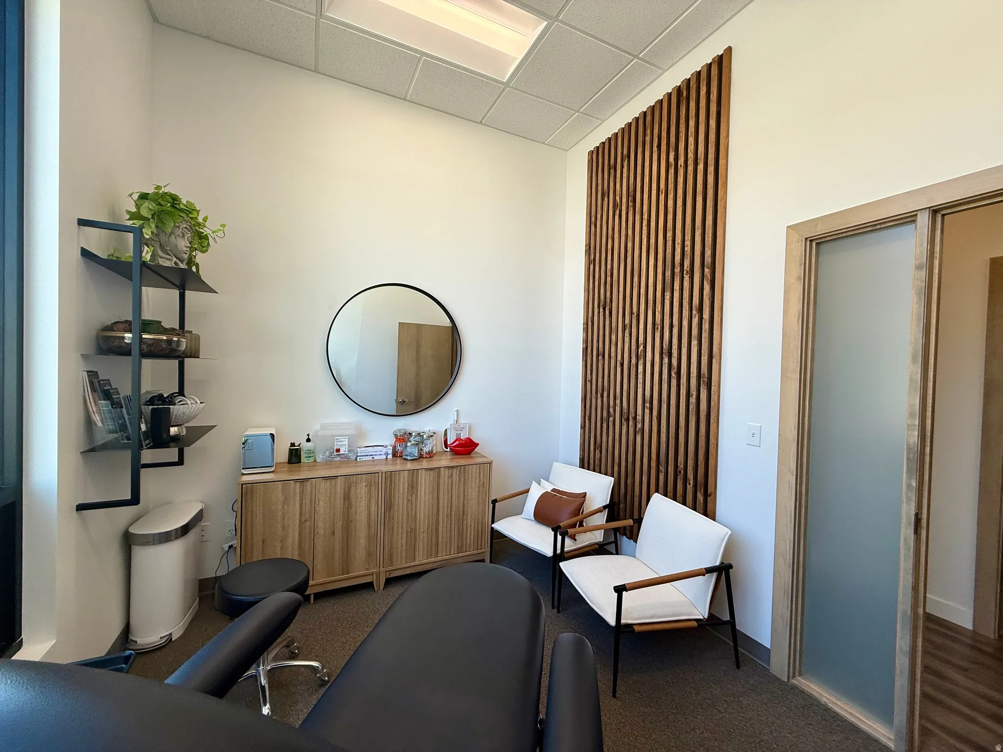 Interior space featuring a vertical wood slat wall panel, recessed lighting, and a frosted glass sliding door