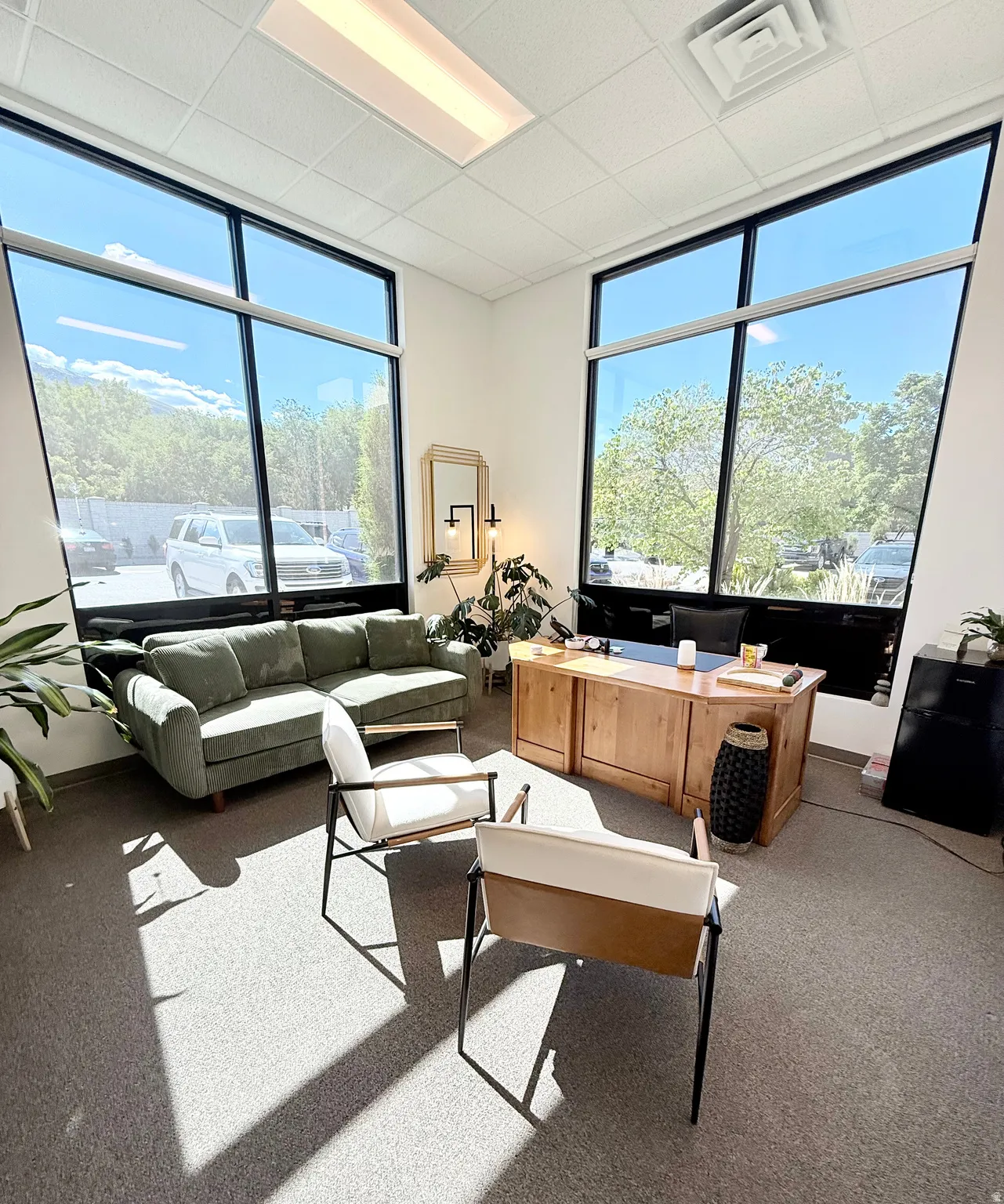 Corner office space featuring expansive windows, recessed lighting, and carpeted flooring