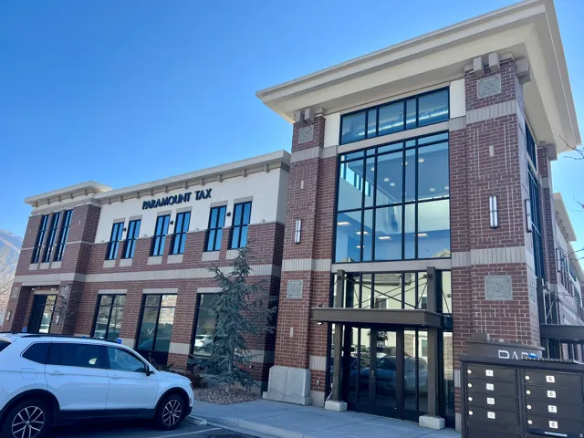 Contemporary commercial building featuring a brick and light-colored facade with ample fenestration