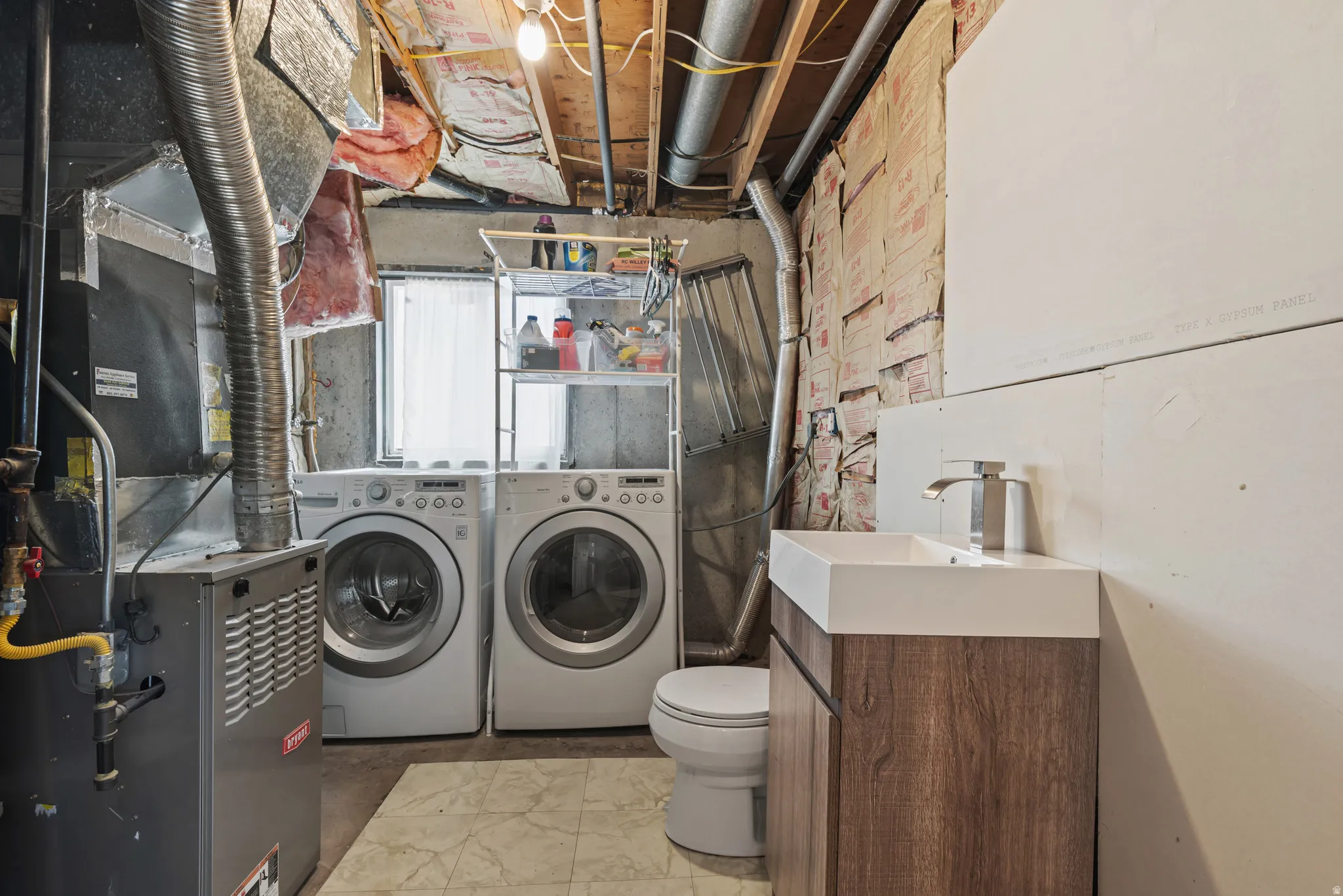 Utility space featuring a modern vanity with a white rectangular sink, wood-finish cabinetry, and a chrome faucet