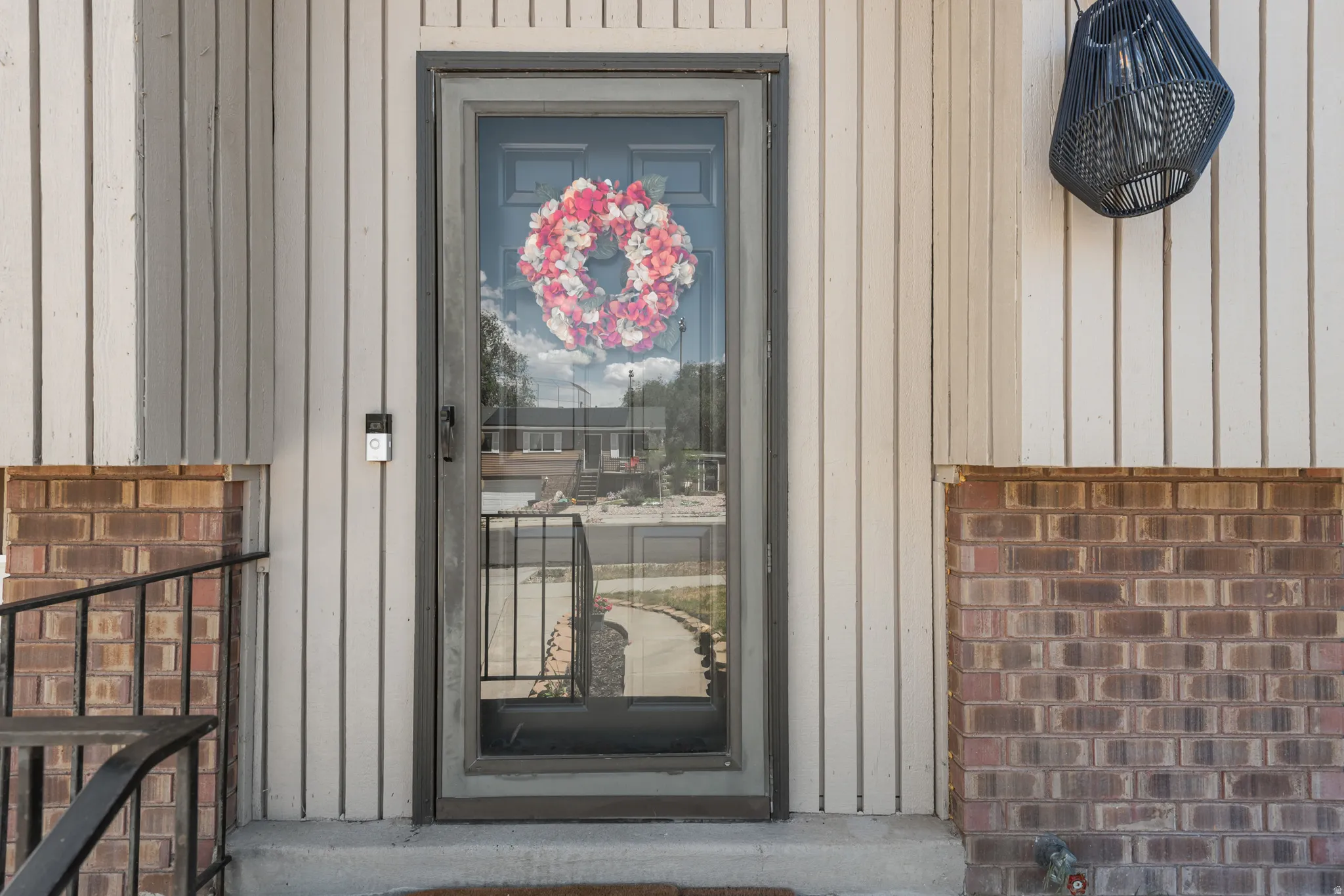 Front entry featuring vertical siding and brick accents
