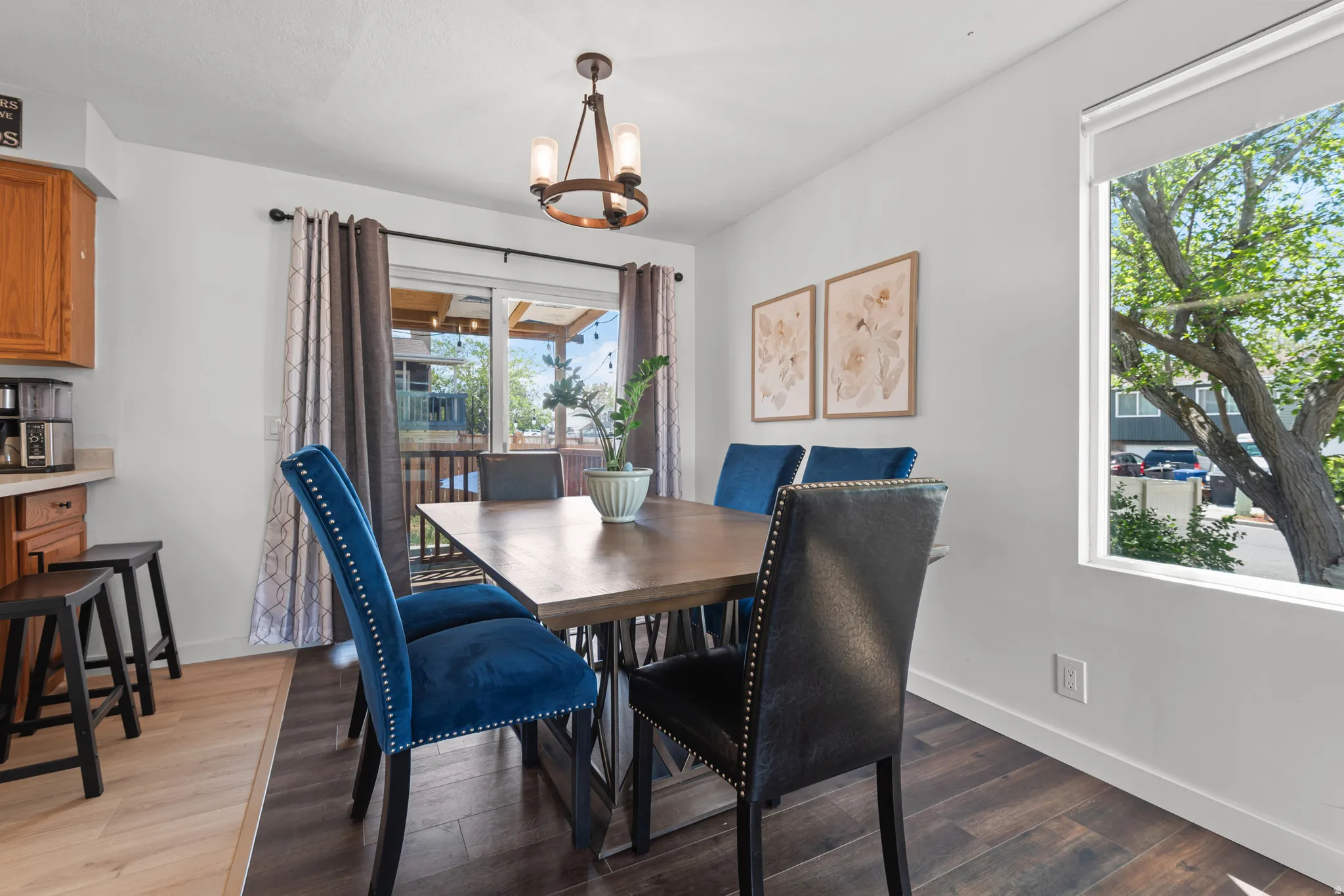 Dining area featuring wood-finish flooring, a contemporary chandelier, and a sliding glass door providing access to an outdoor area