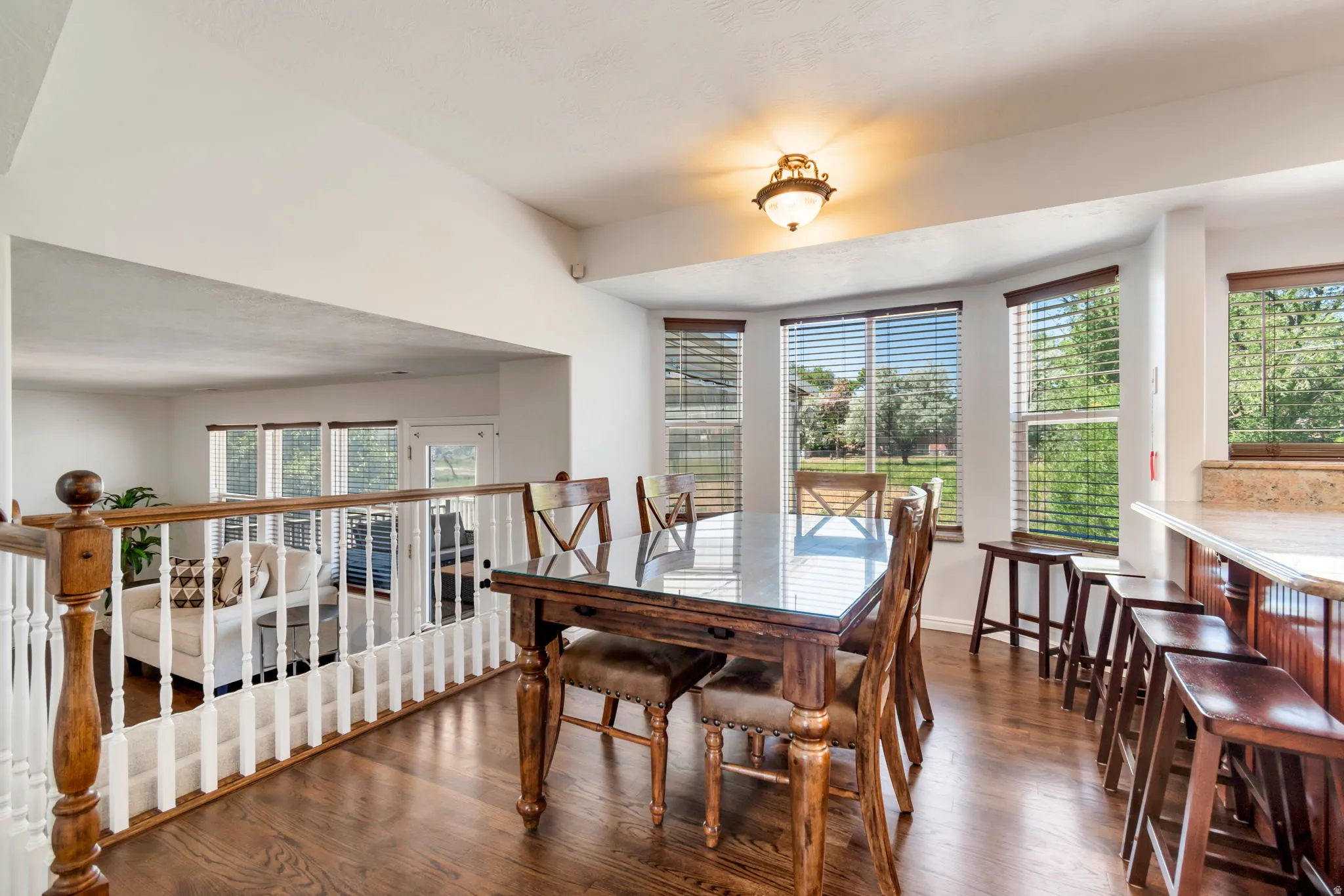 Dining area featuring wood-finish flooring and a built-in breakfast bar with stone countertop