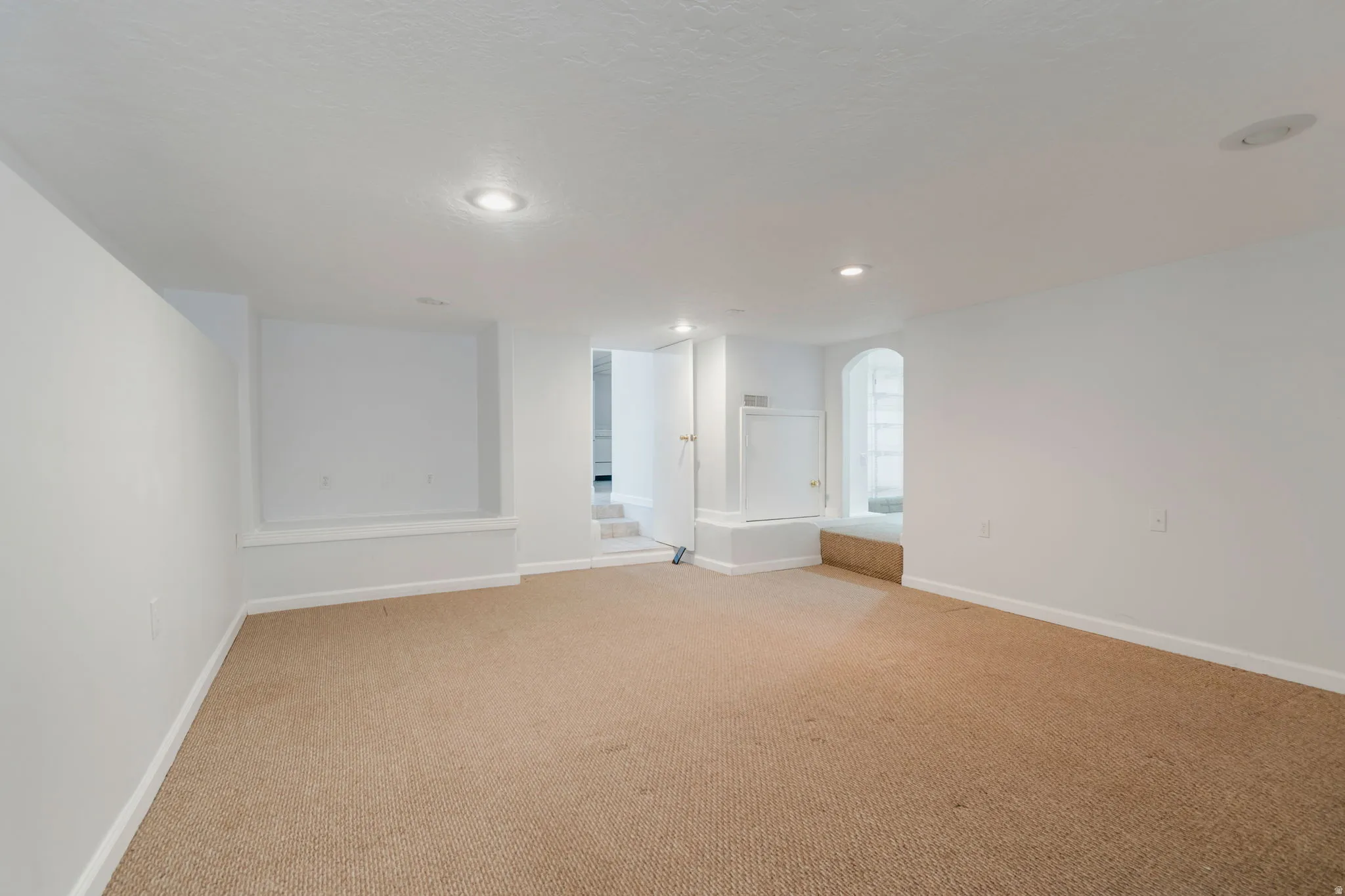 Carpeted room with recessed lighting and white painted walls
