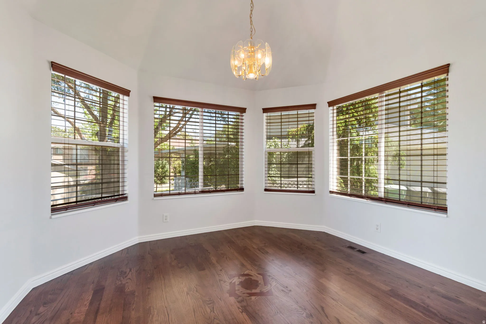 Vaulted ceilings crown this space featuring dark wood-finish flooring
