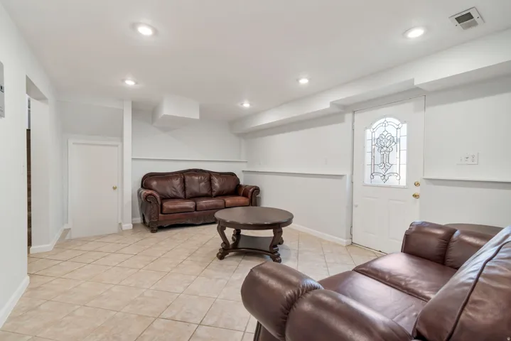 Recessed lighting illuminates this space featuring tile flooring and a white door with decorative glass