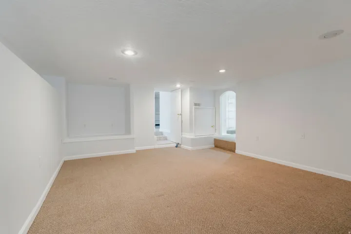 Carpeted room with recessed lighting and white painted walls