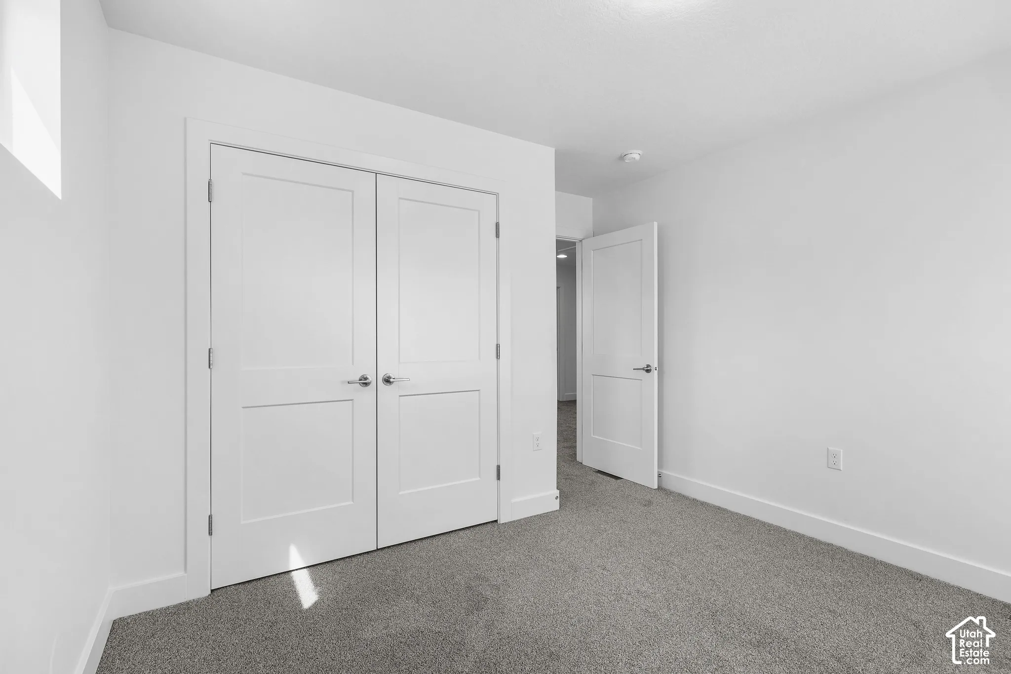 Neutral wall finishes and gray carpeting with white trim work