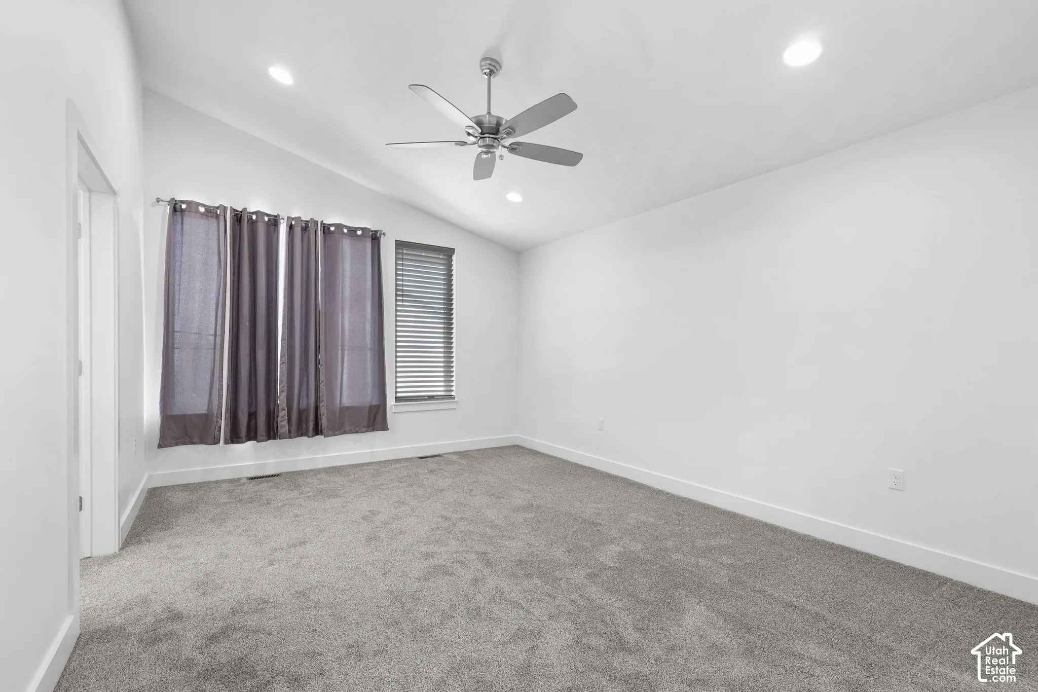 Vaulted ceiling with recessed lighting and a ceiling fan, plush gray carpeting, and window blinds