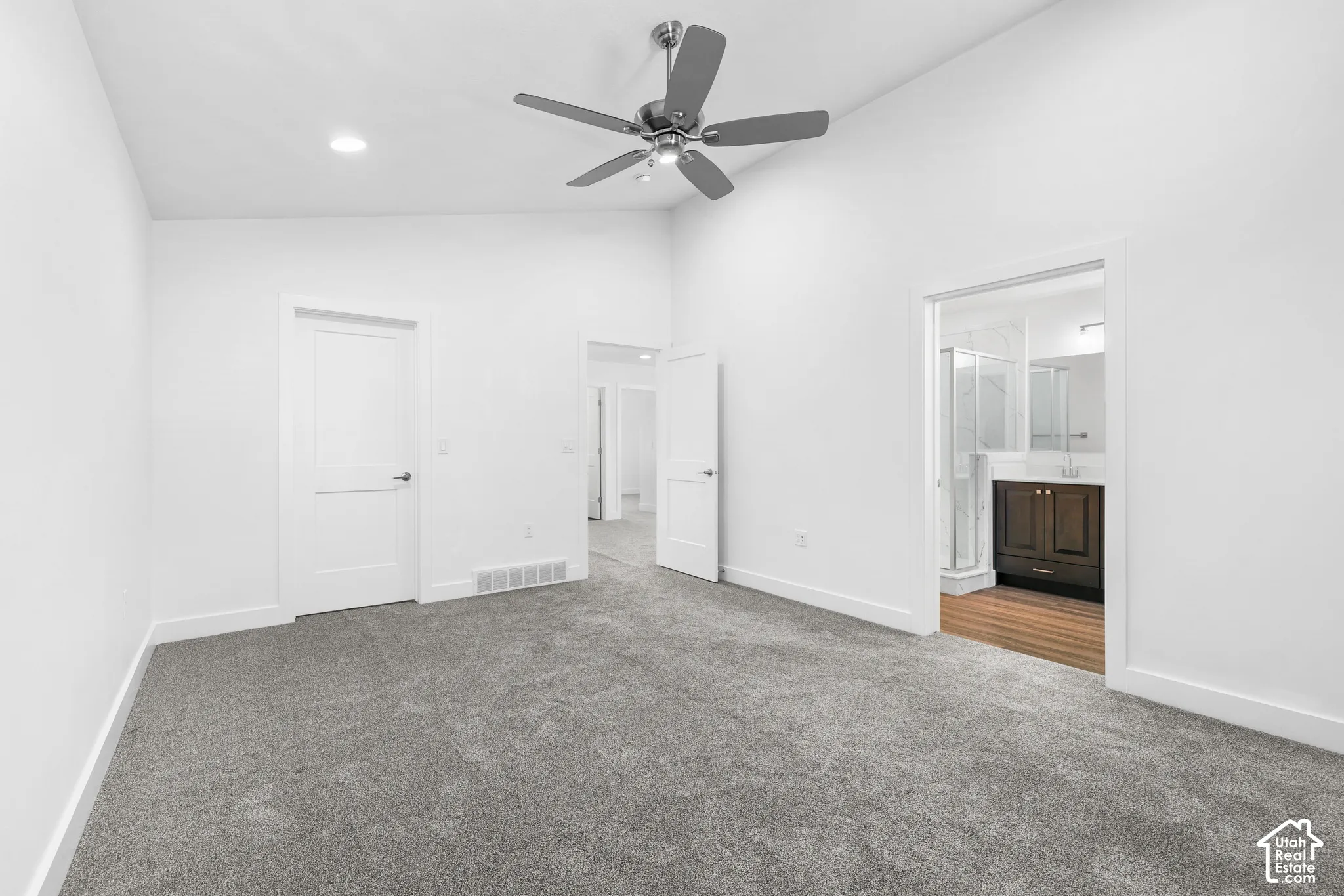 Vaulted ceiling with a ceiling fan, recessed lighting, and soft gray carpeting