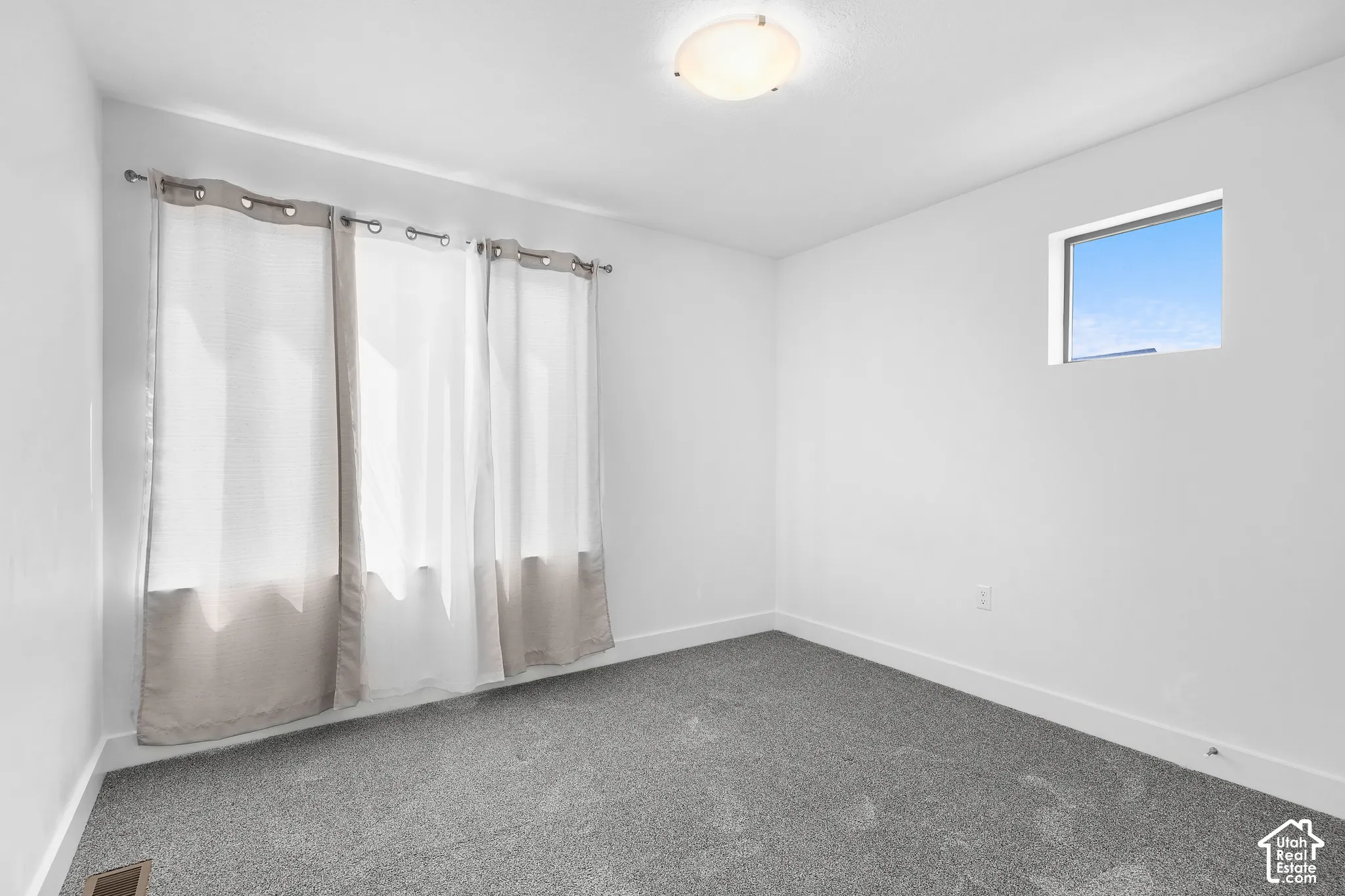 Recessed window, flush mount ceiling fixture, and light gray carpeting