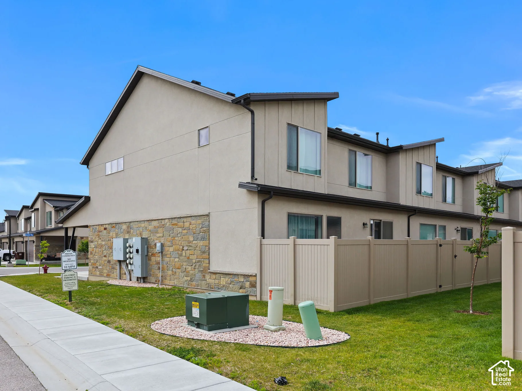 Contemporary multi-level townhome featuring stucco and stone veneer exterior