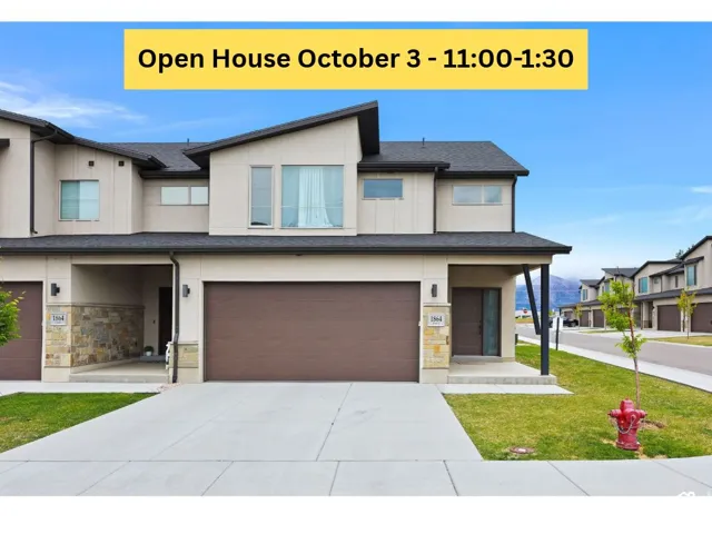 Modern exterior with mixed material facade, integrated two-car garage, covered entry, and paved driveway