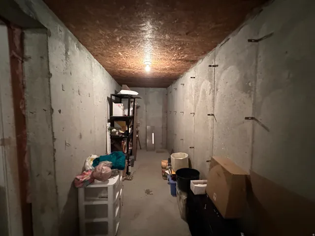 Concrete-walled storage area under front porch area.