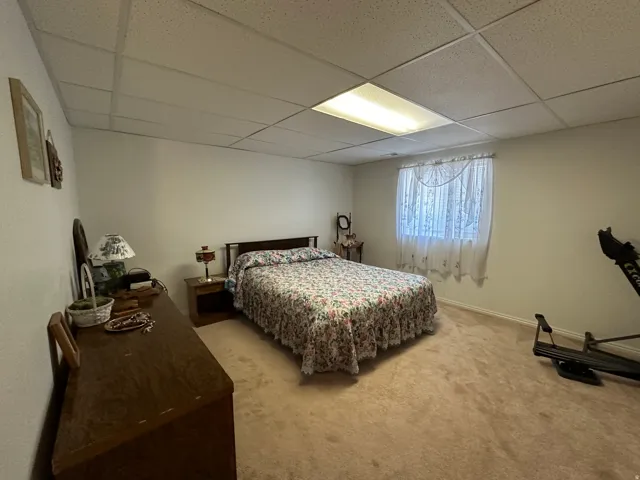 Carpeted interior space featuring a drop ceiling with recessed lighting