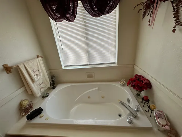 Built-in jetted tub with chrome fixtures, integrated into a tiled surround