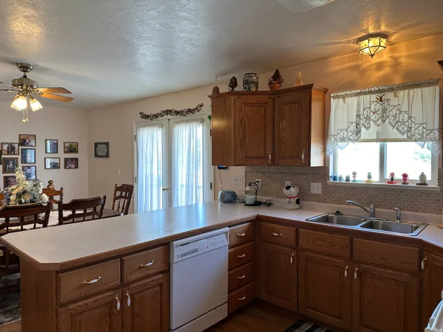 Spacious kitchen featuring oak cabinetry, light-toned countertops, and a full tile backsplash