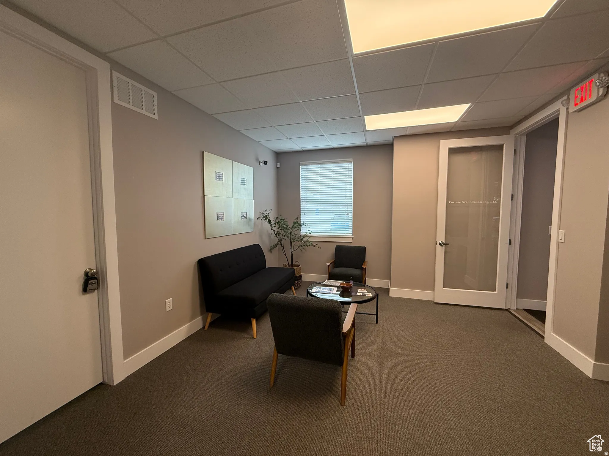 Commercial space featuring neutral-toned walls, recessed lighting, and a suspended acoustic ceiling