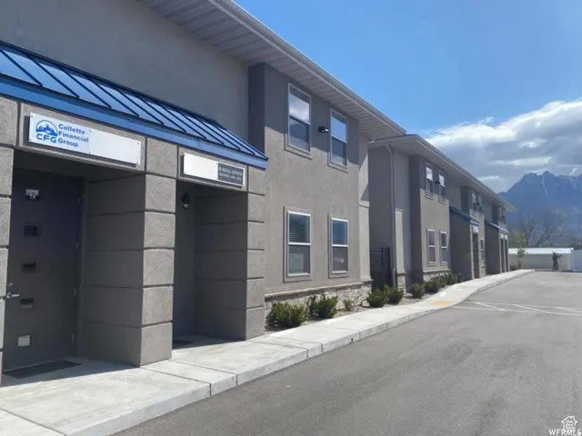 Two-story commercial building featuring a stucco exterior and a blue metal awning