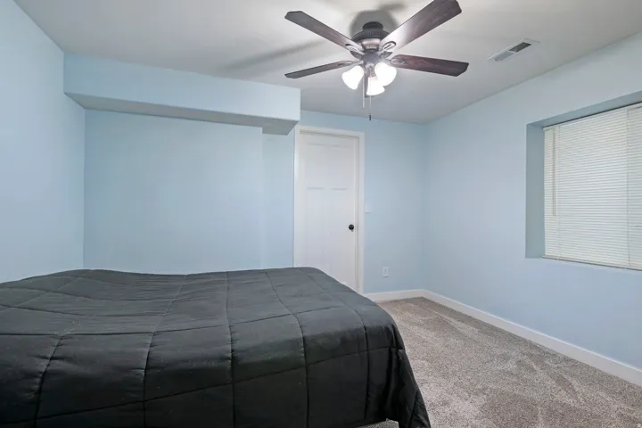Light blue painted walls with white trim and grey carpet flooring