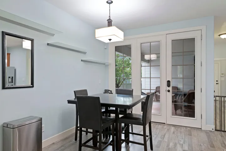 Dining area featuring light wood-finish flooring and a contemporary pendant light fixture
